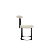 The Claudia round dining chair with a sleek, modern design, perfect for contemporary dining spaces.
